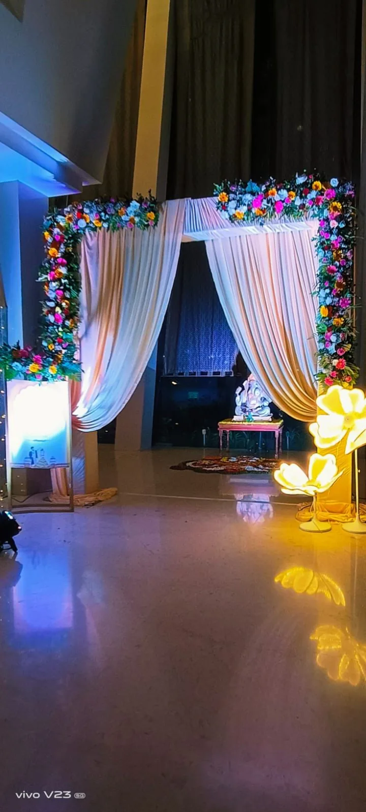 Floral arch inside, lit warm — event by Plan With YOLO, Pune