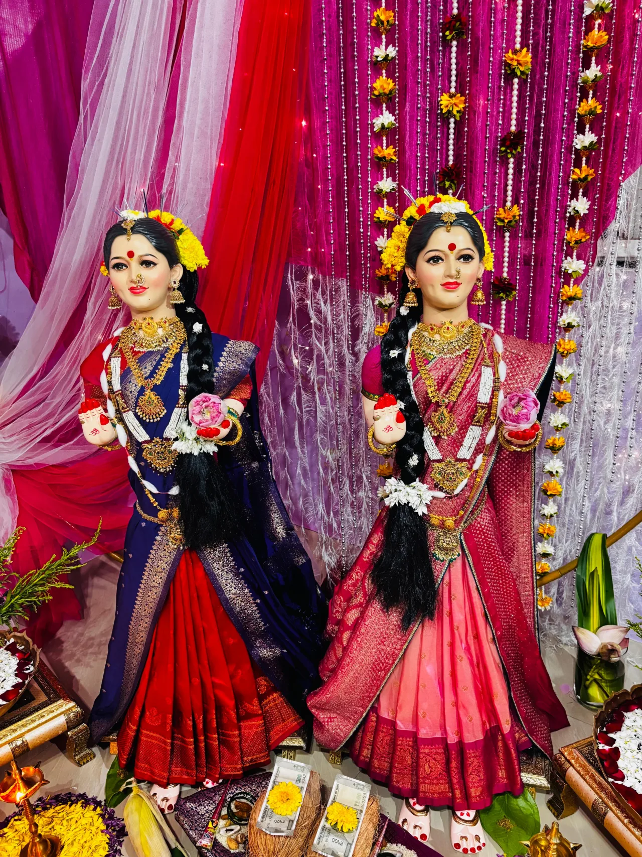 Gauri idols in sarees against a pink drape — event by Plan With YOLO, Pune