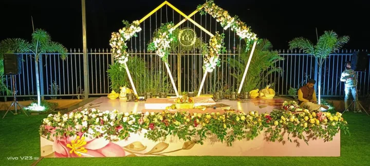 Haldi stage on a lawn with a geometric arch — event by Plan With YOLO, Pune
