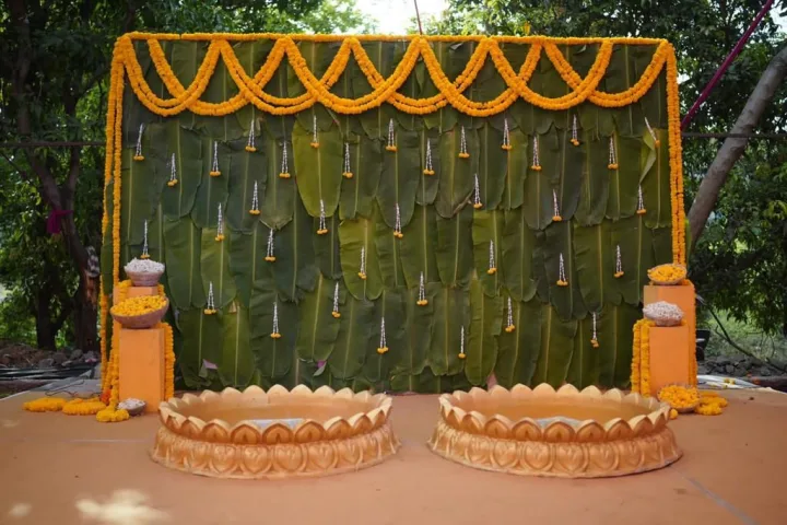 Banana leaf and marigold backdrop for a haldi — event by Plan With YOLO, Pune