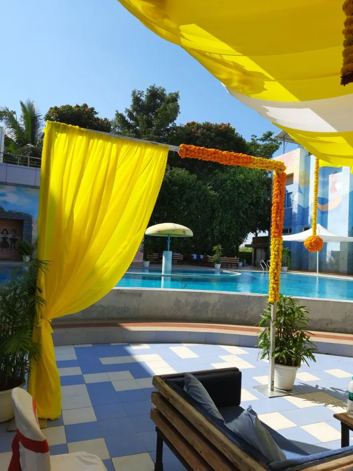 Yellow drape and marigold entrance by the pool — event by Plan With YOLO, Pune
