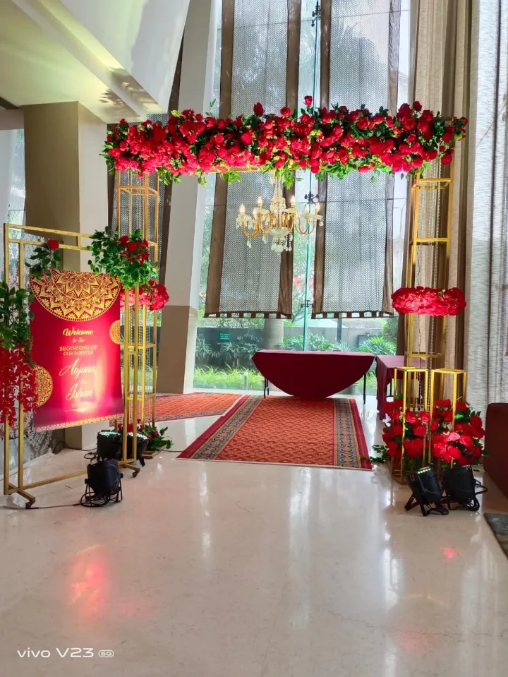 Red rose arch with a chandelier — event by Plan With YOLO, Pune