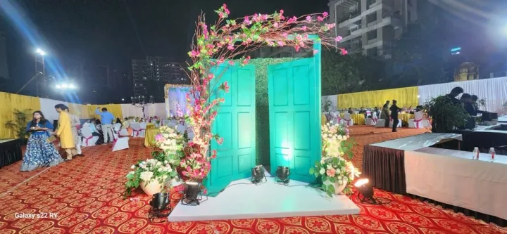 Teal doors framed in flowers — event by Plan With YOLO, Pune