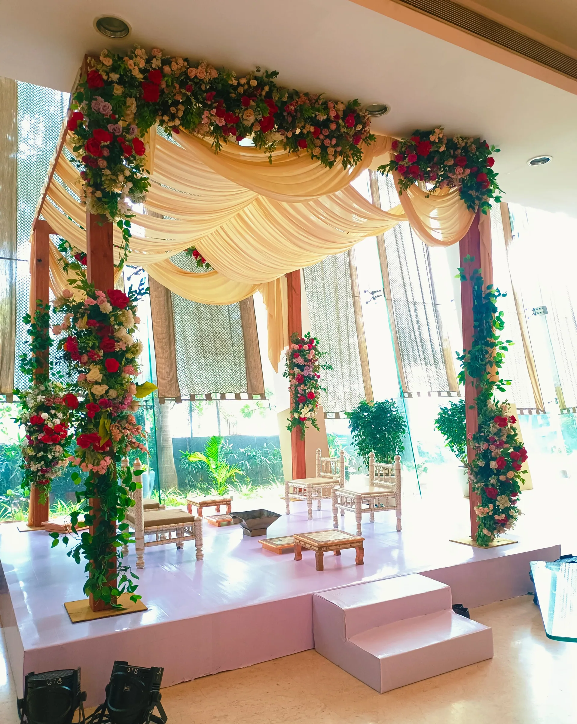 Reception stage built on a lawn, gold arches — event by Plan With YOLO, Pune