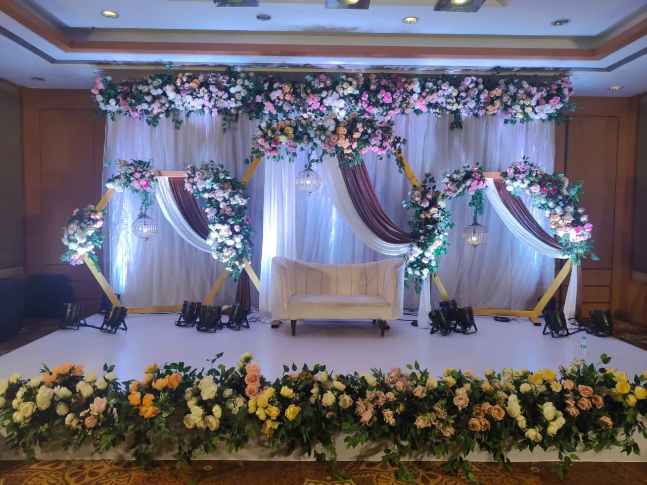 Twin floral arches on a banquet stage — event by Plan With YOLO, Pune
