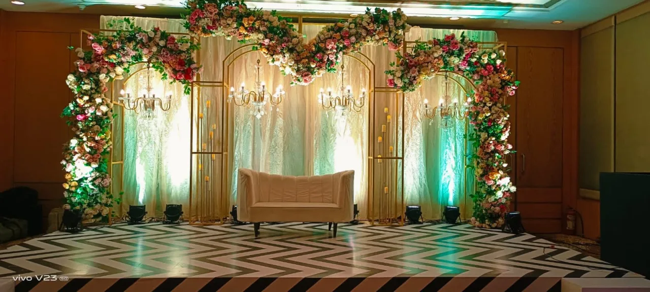 Floral arch and sofa under warm light — event by Plan With YOLO, Pune