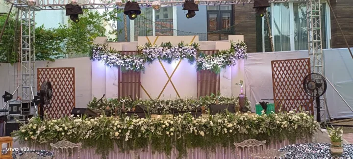 Long floral table on an outdoor stage — event by Plan With YOLO, Pune